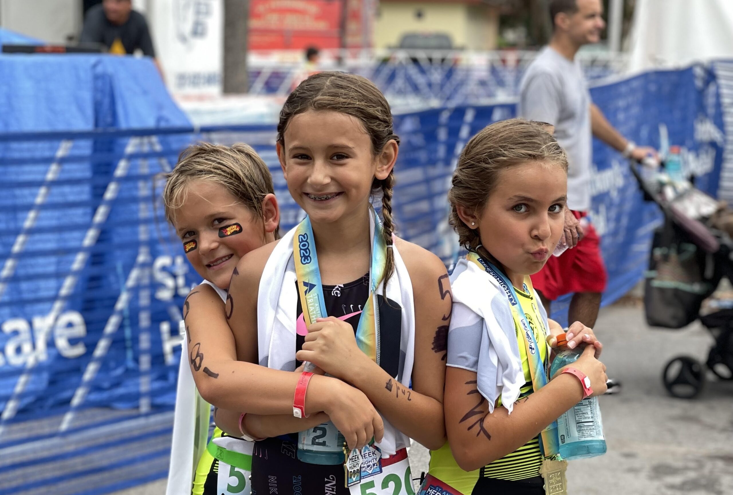 3 girl near a pool smiling and hugging